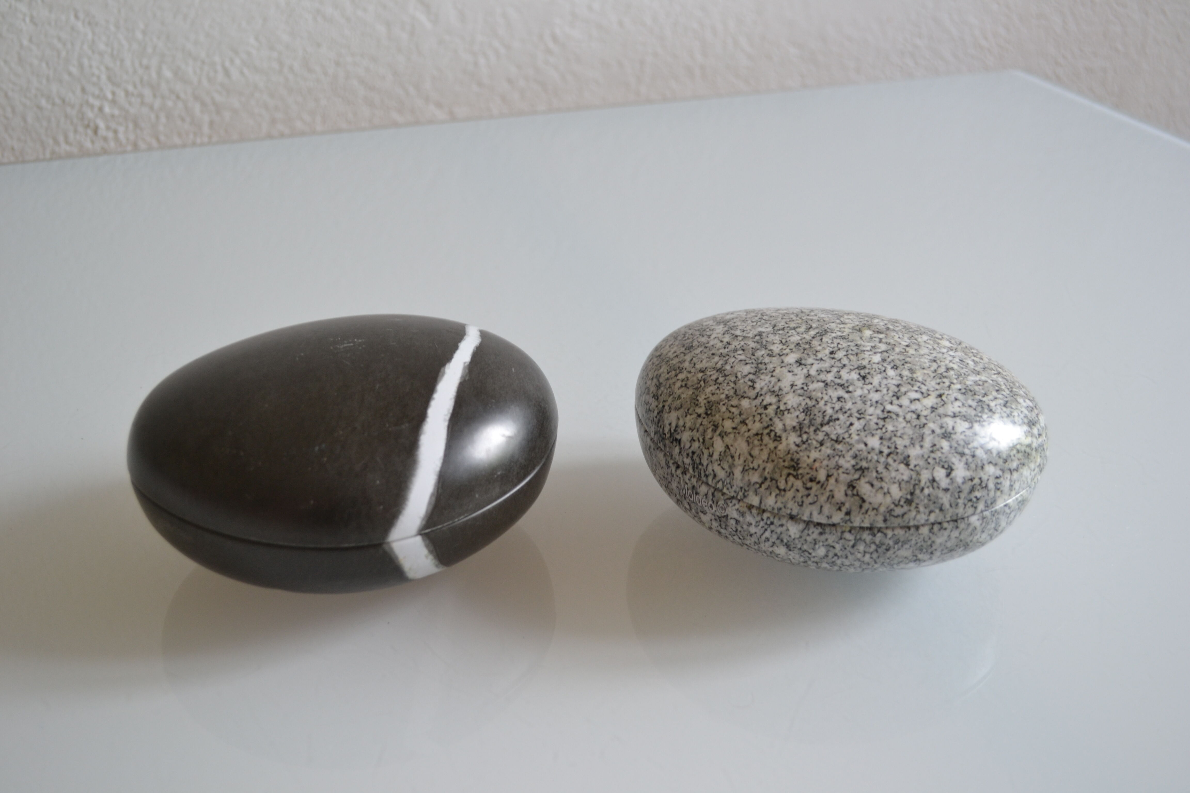 2 boxes in lithographed sheet metal in the shape of a pebble