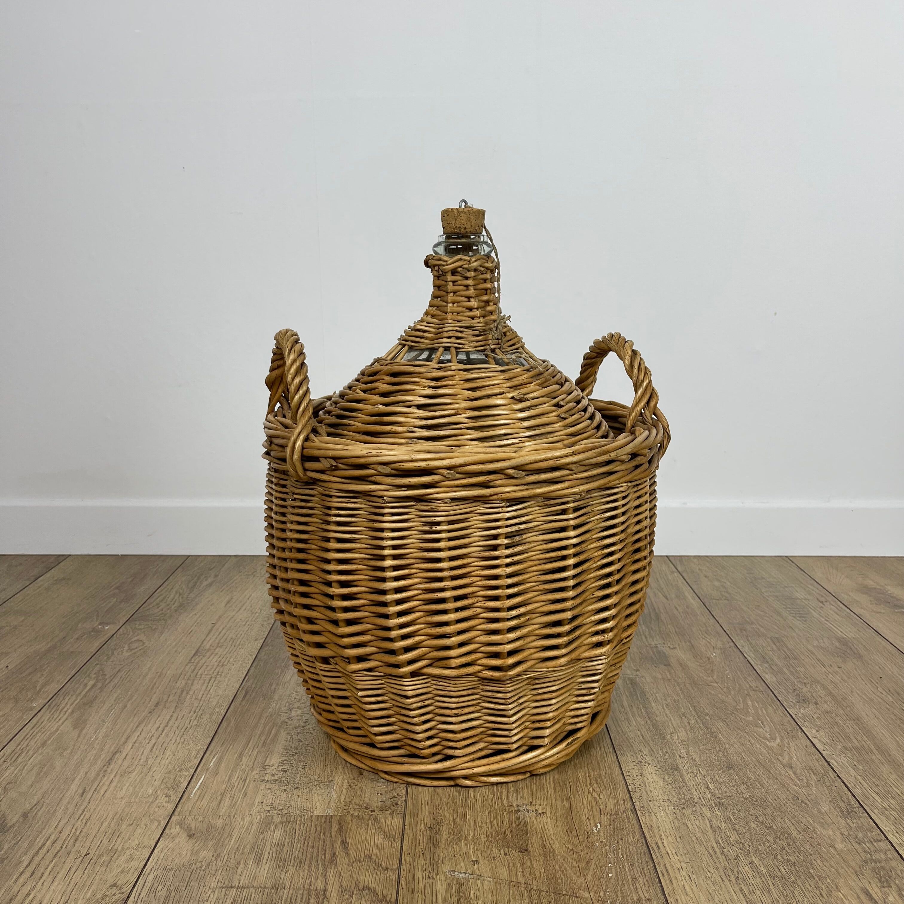 Old demijohn in her wicker basket