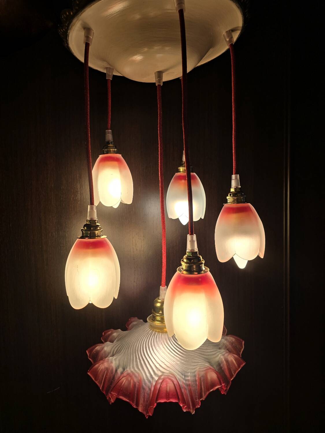 Suspension with tulips and a red scalloped lampshade.