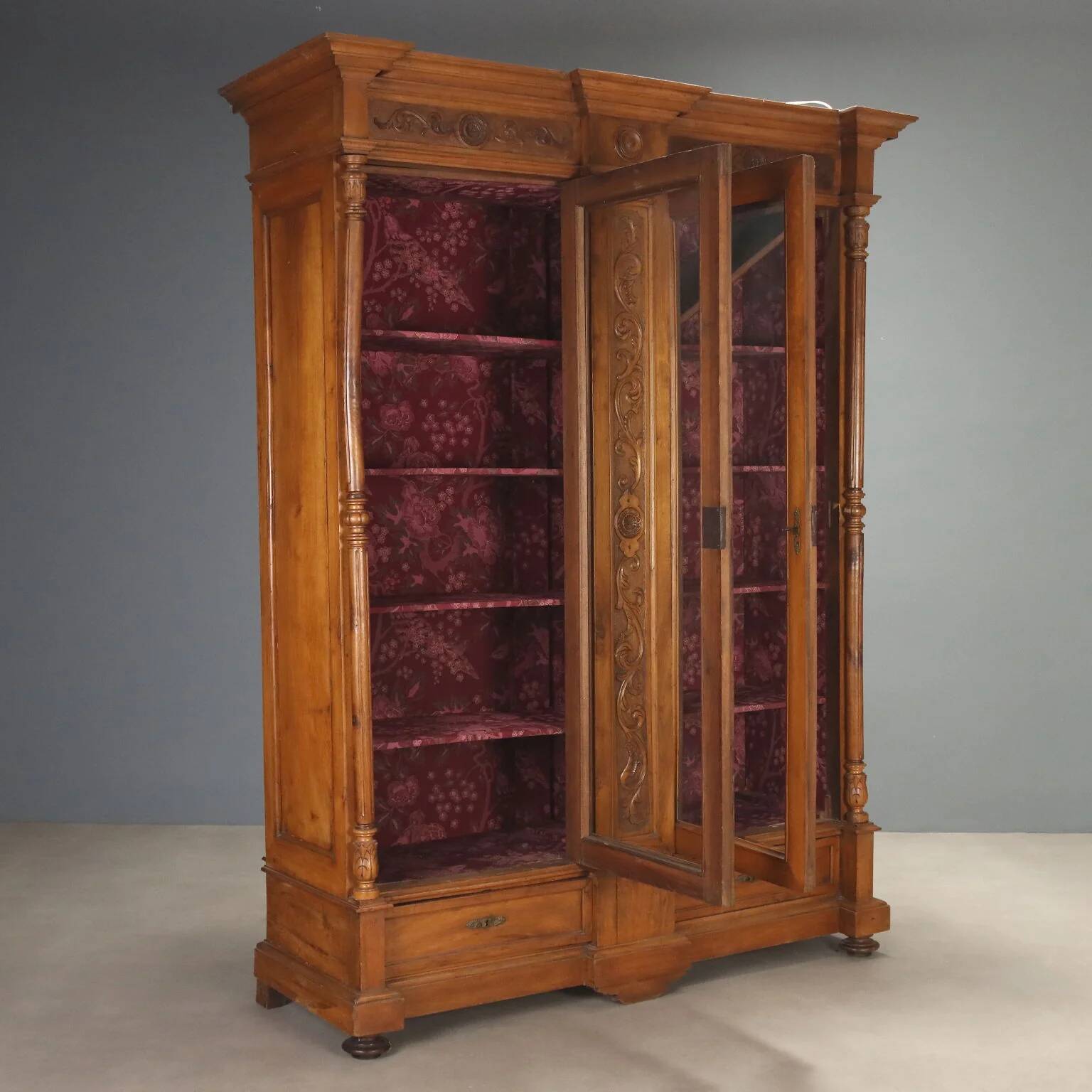 Antique walnut wardrobe with glass and carvings, Italy, 19th century.