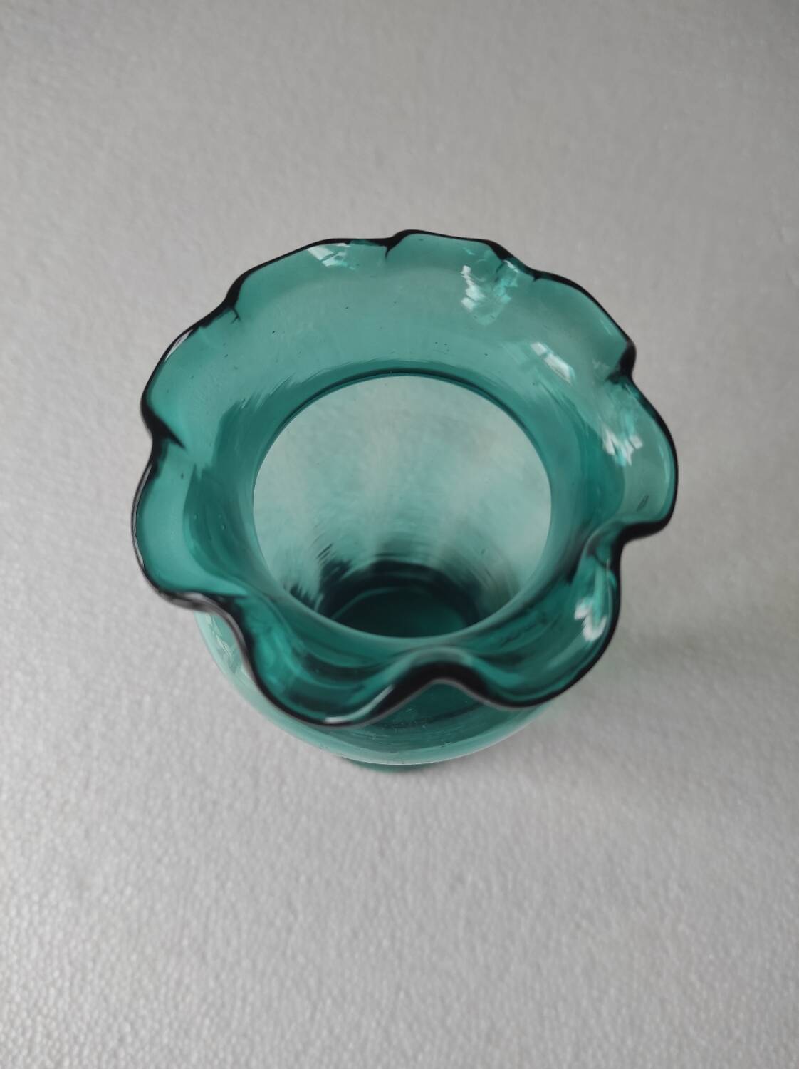 Blown glass vase with a flared neck and wavy rim.