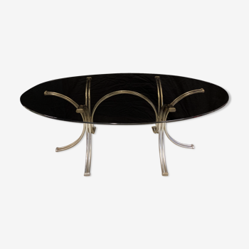Table ovale en verre fumé pieds arcs en acier chromé
