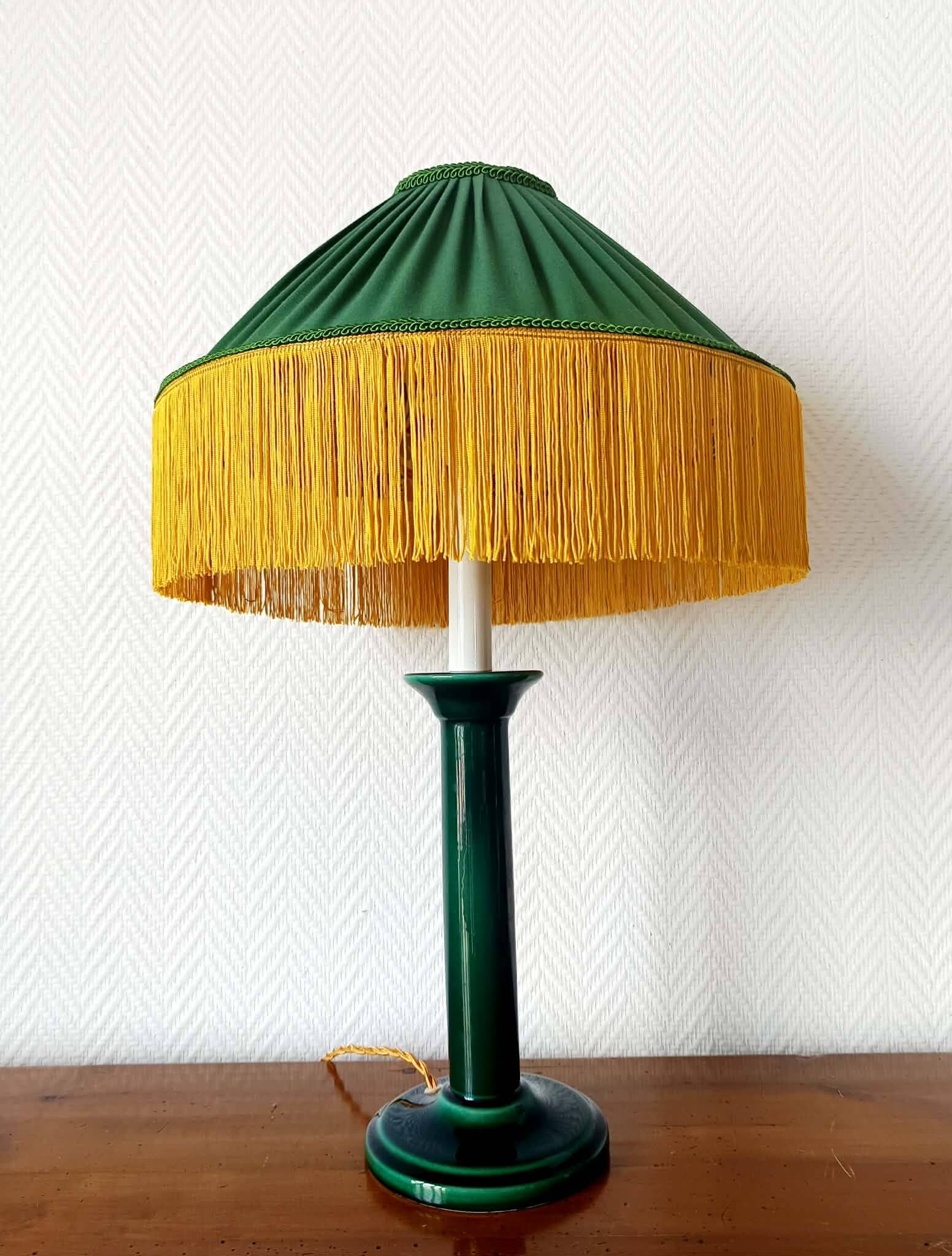 Green ceramic lamp with a vintage pleated fringe shade.