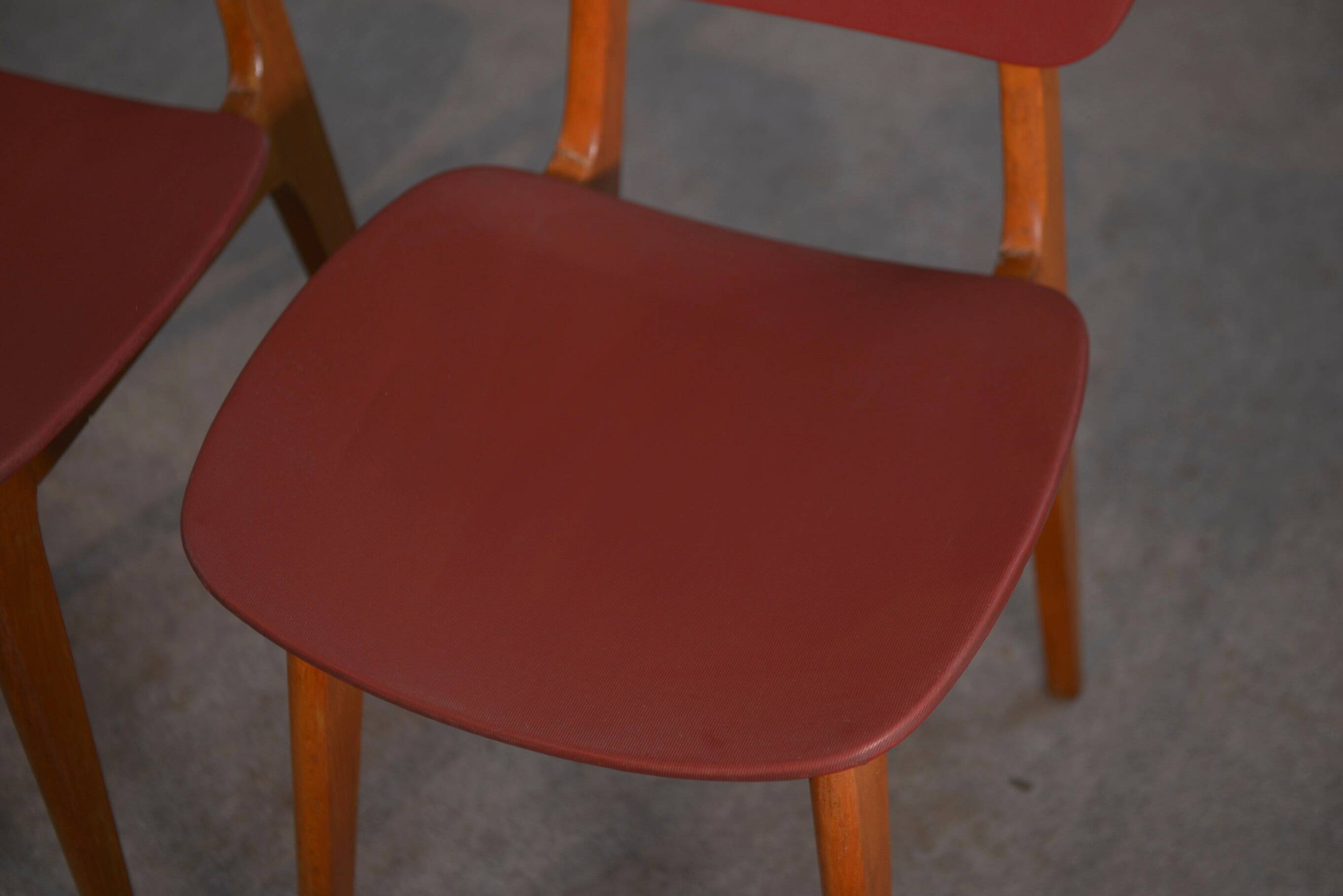 Set of 4 designer chairs in oak and red leatherette from the 1960s