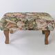Large vintage upholstered footstool with curved legs.