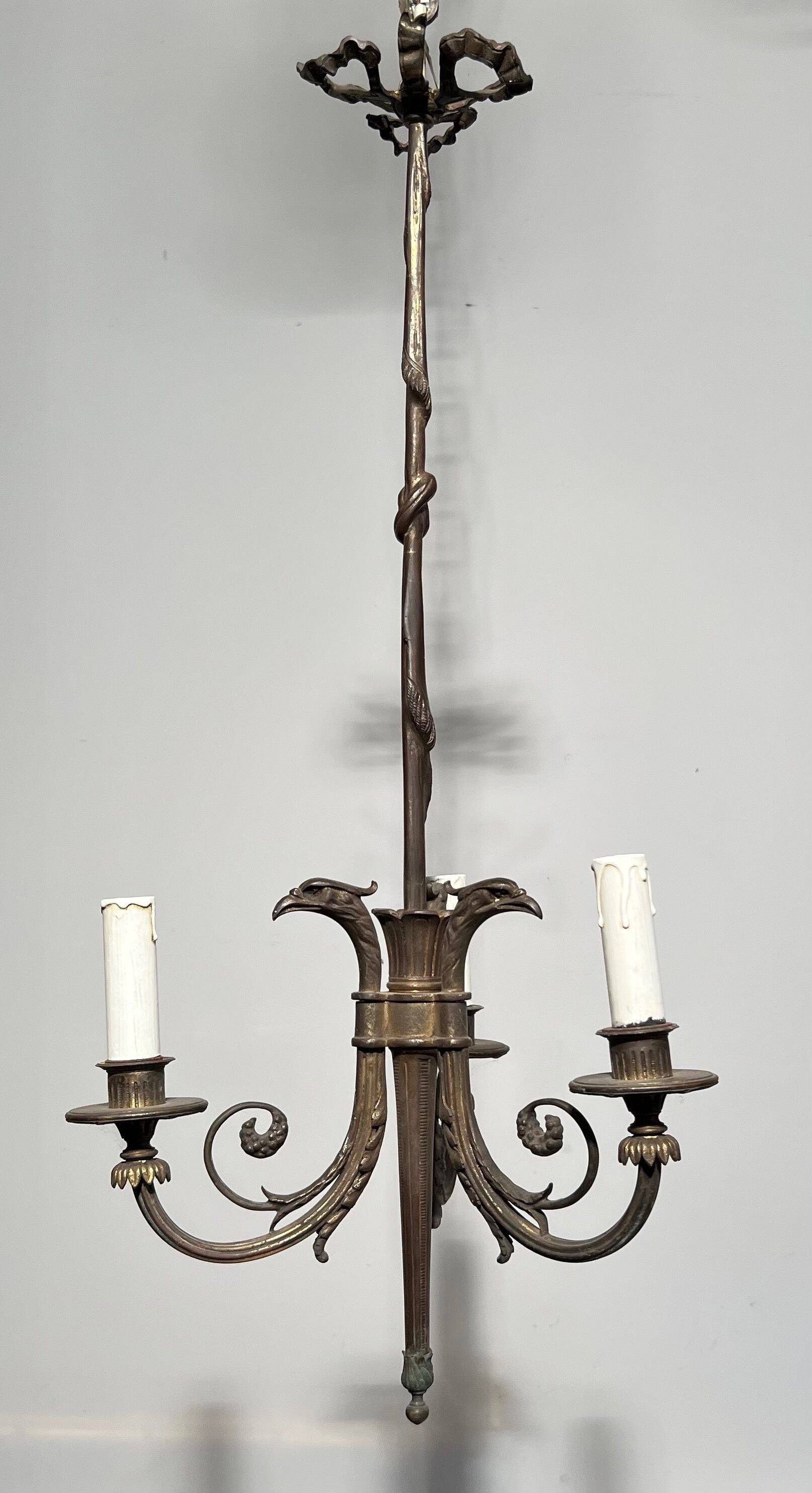 Empire-style bronze chandelier with 3 arms of light topped with eagle heads. French work. Circa 1900.