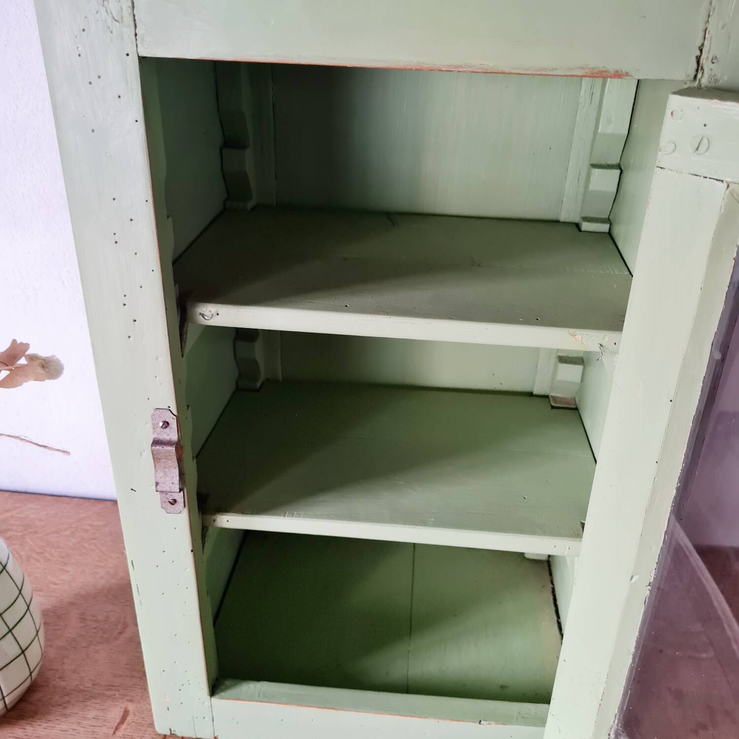 Small glass cabinet in green colour.