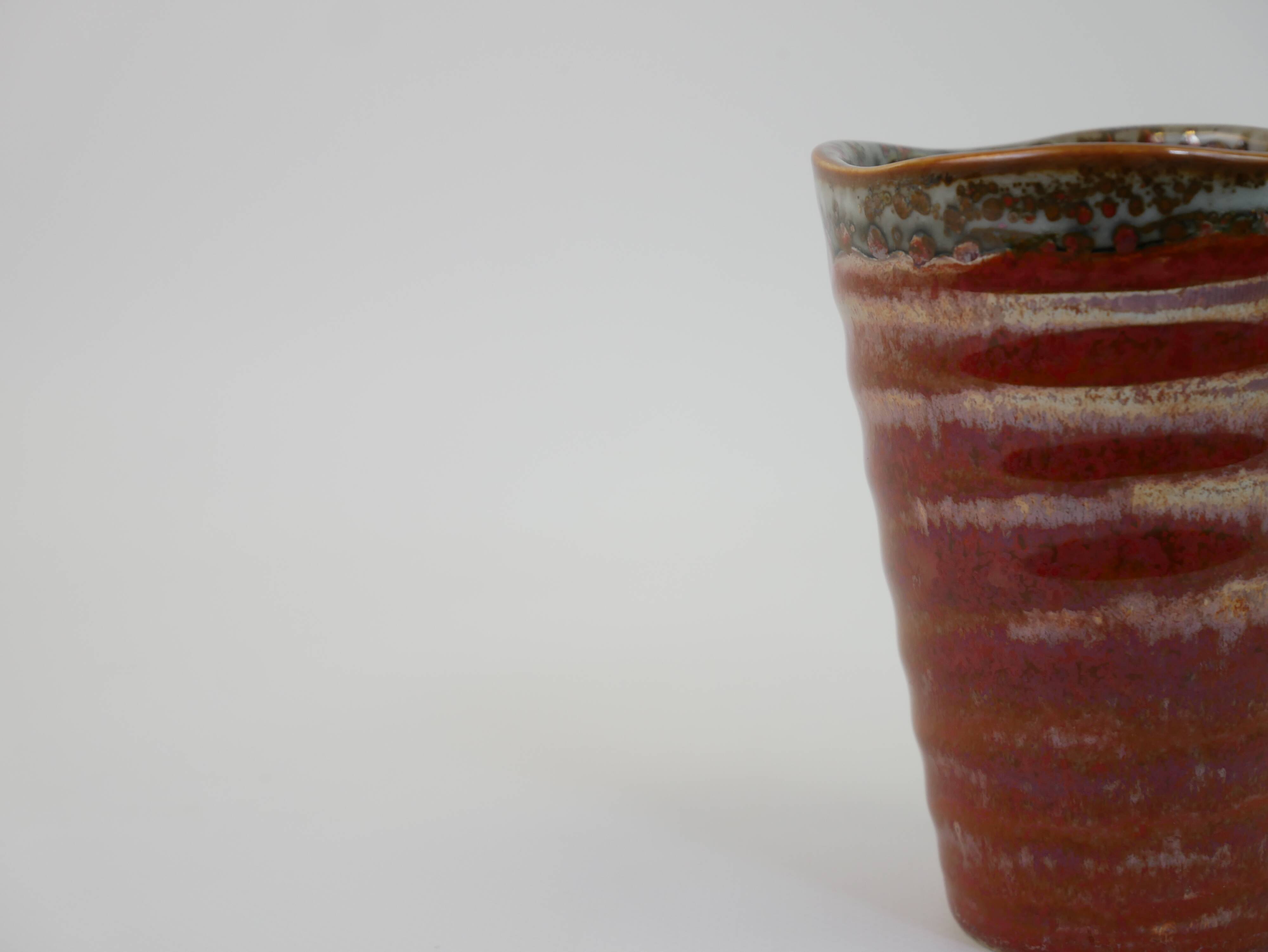 Small orange glazed ceramic cup