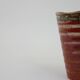 Small orange glazed ceramic cup