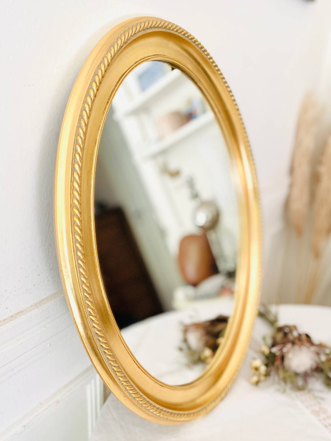 Oval wall mirror in gilded wood