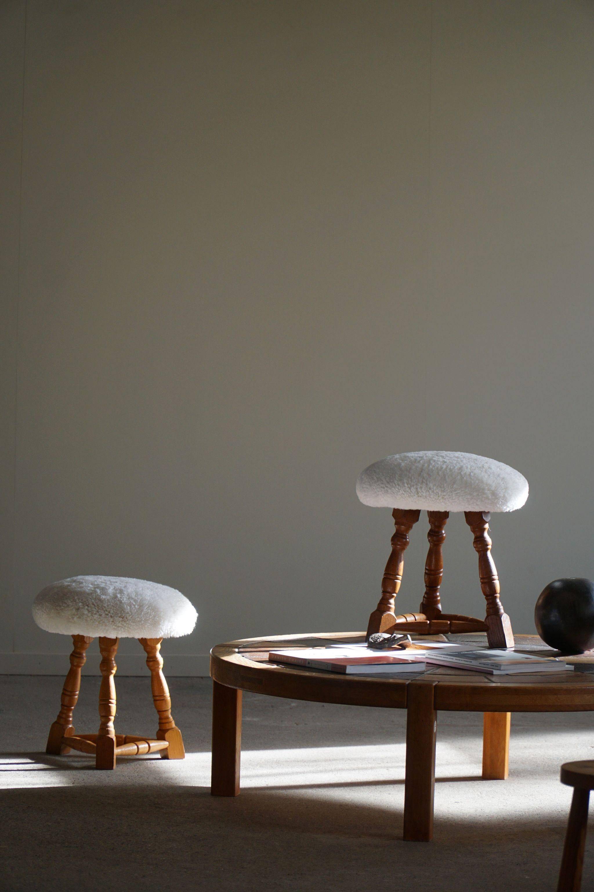 Modern Danish, a pair of tripod stools, seats reupholstered in lambswool, 1950s.