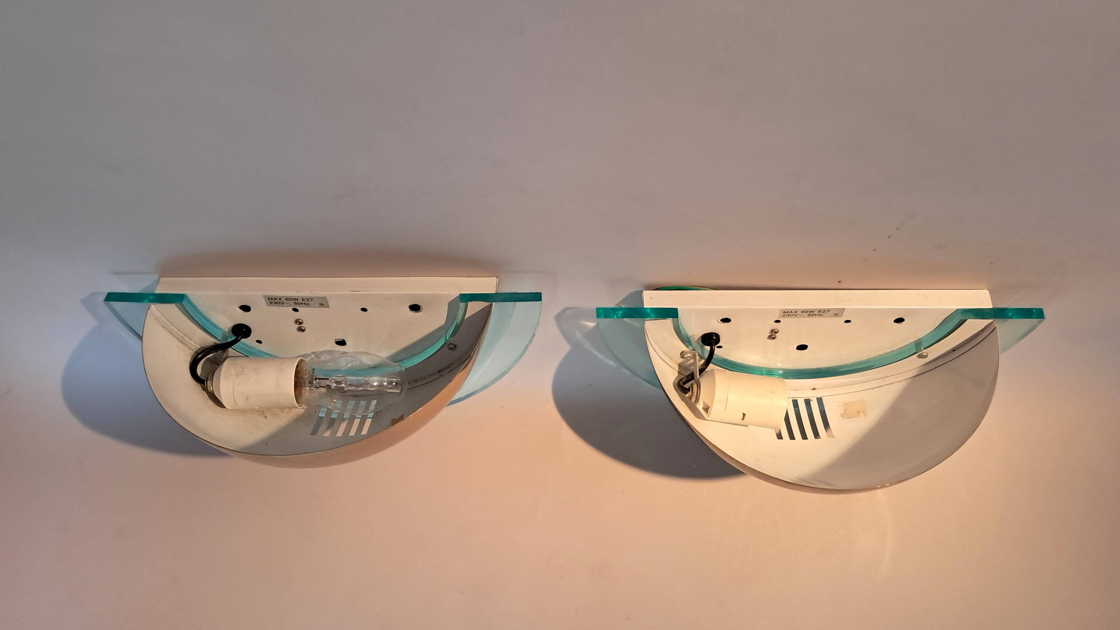 Pair of gold metal and plexiglass wall lights, circa 1980.