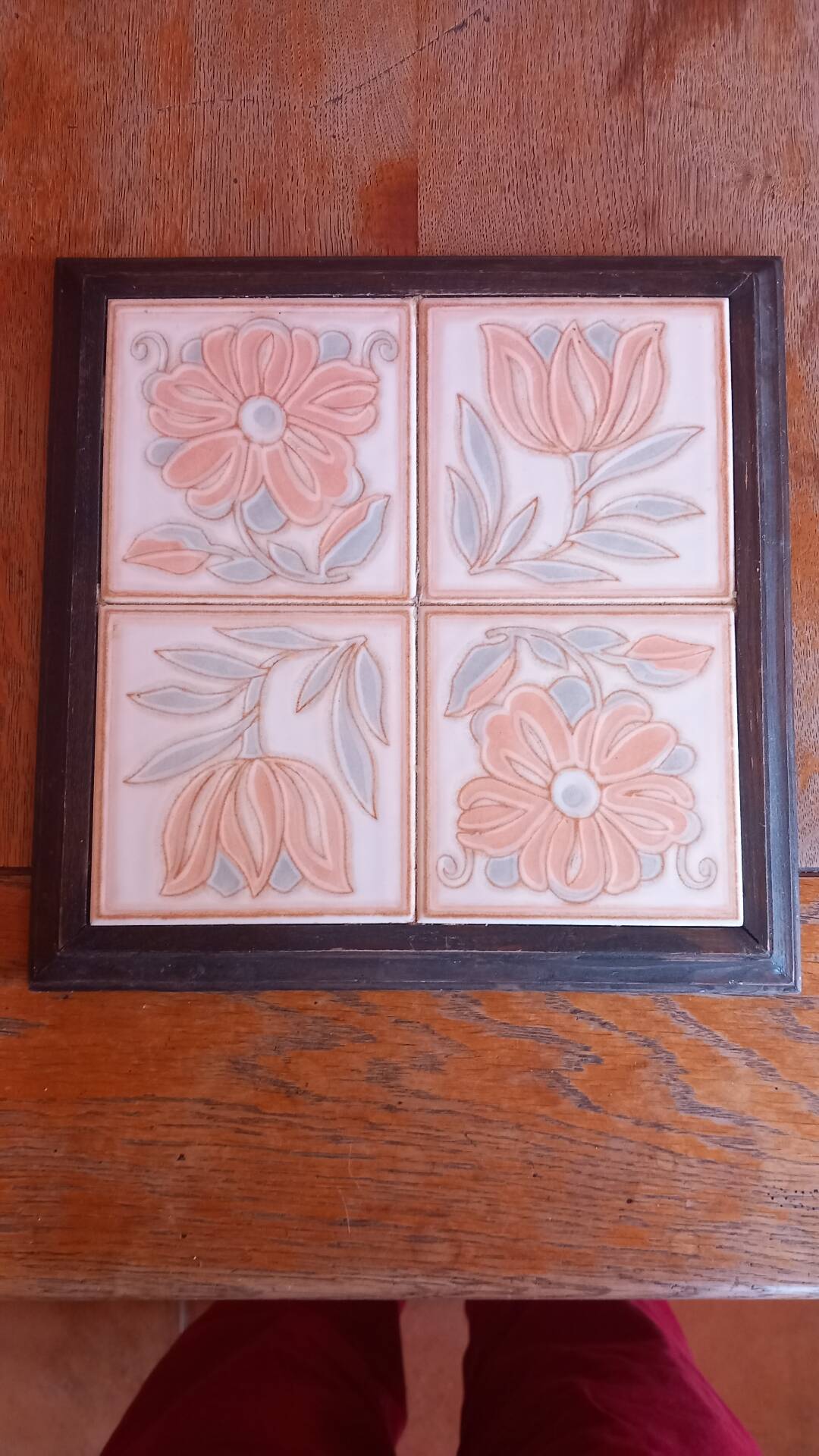 Ceramic tile trivet with floral patterns in pastel tones.