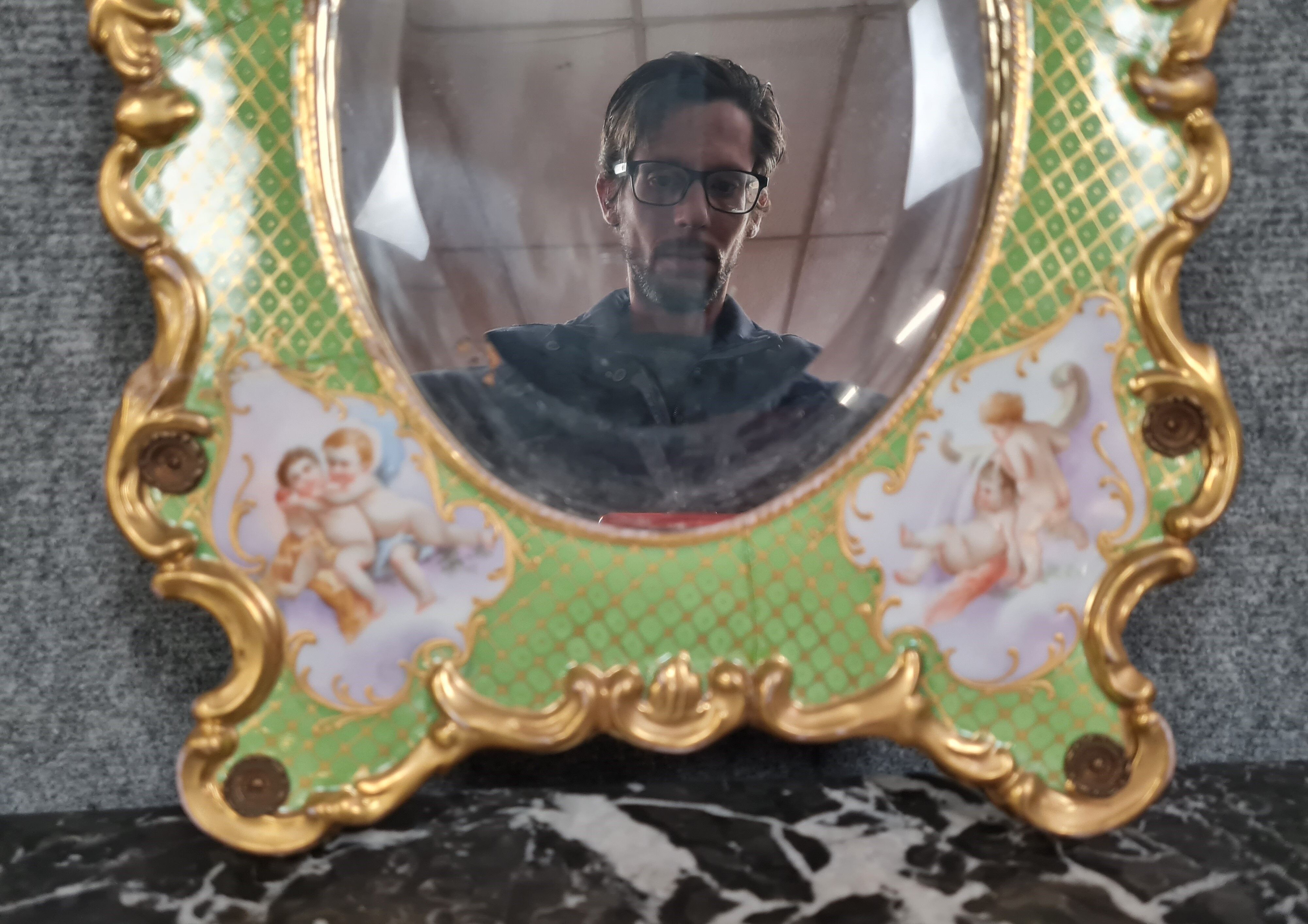 Porcelain mirror with cherub decorations circa 1900