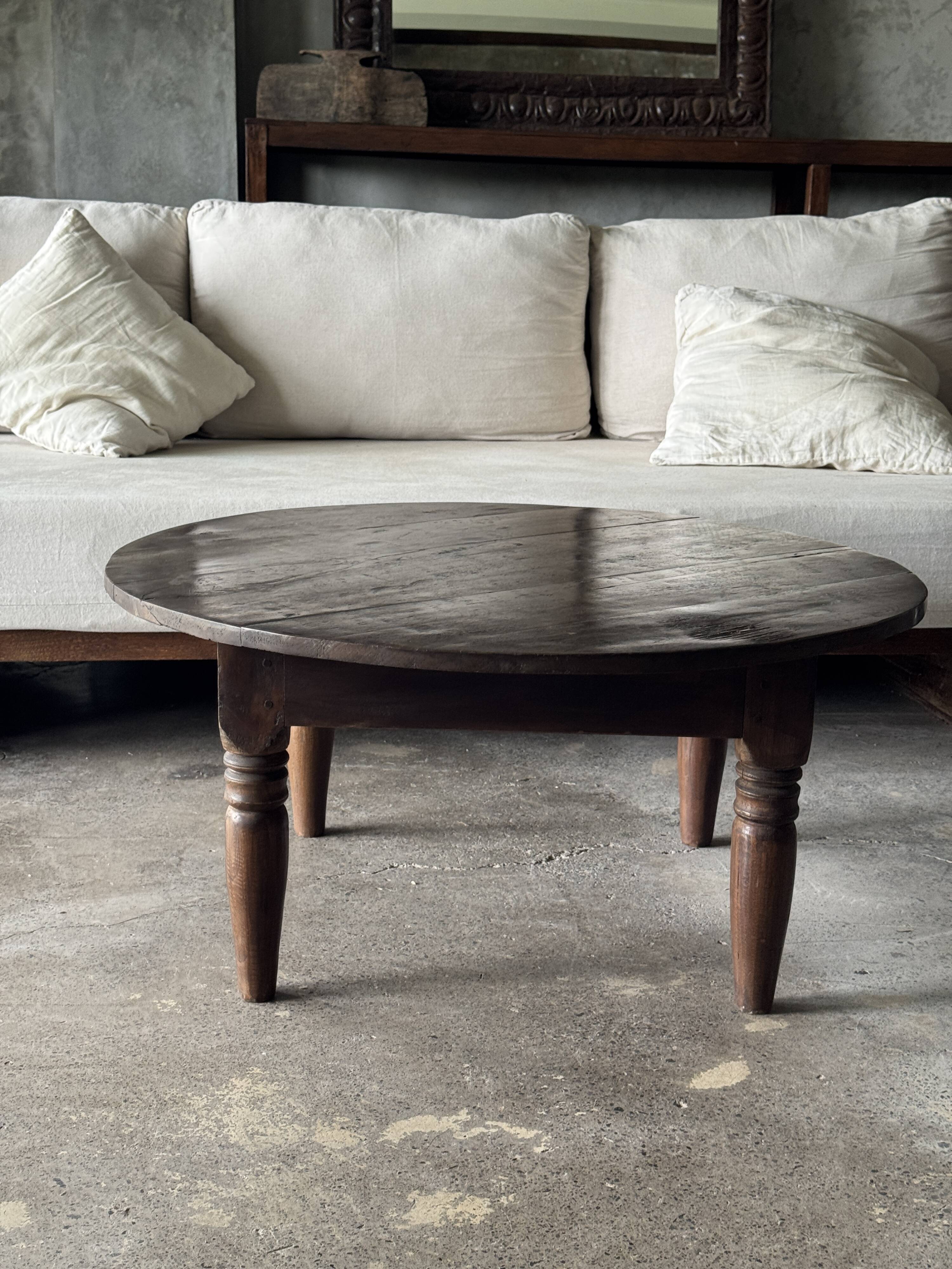Coffee table, round antique Indonesian teak table with straight legs.