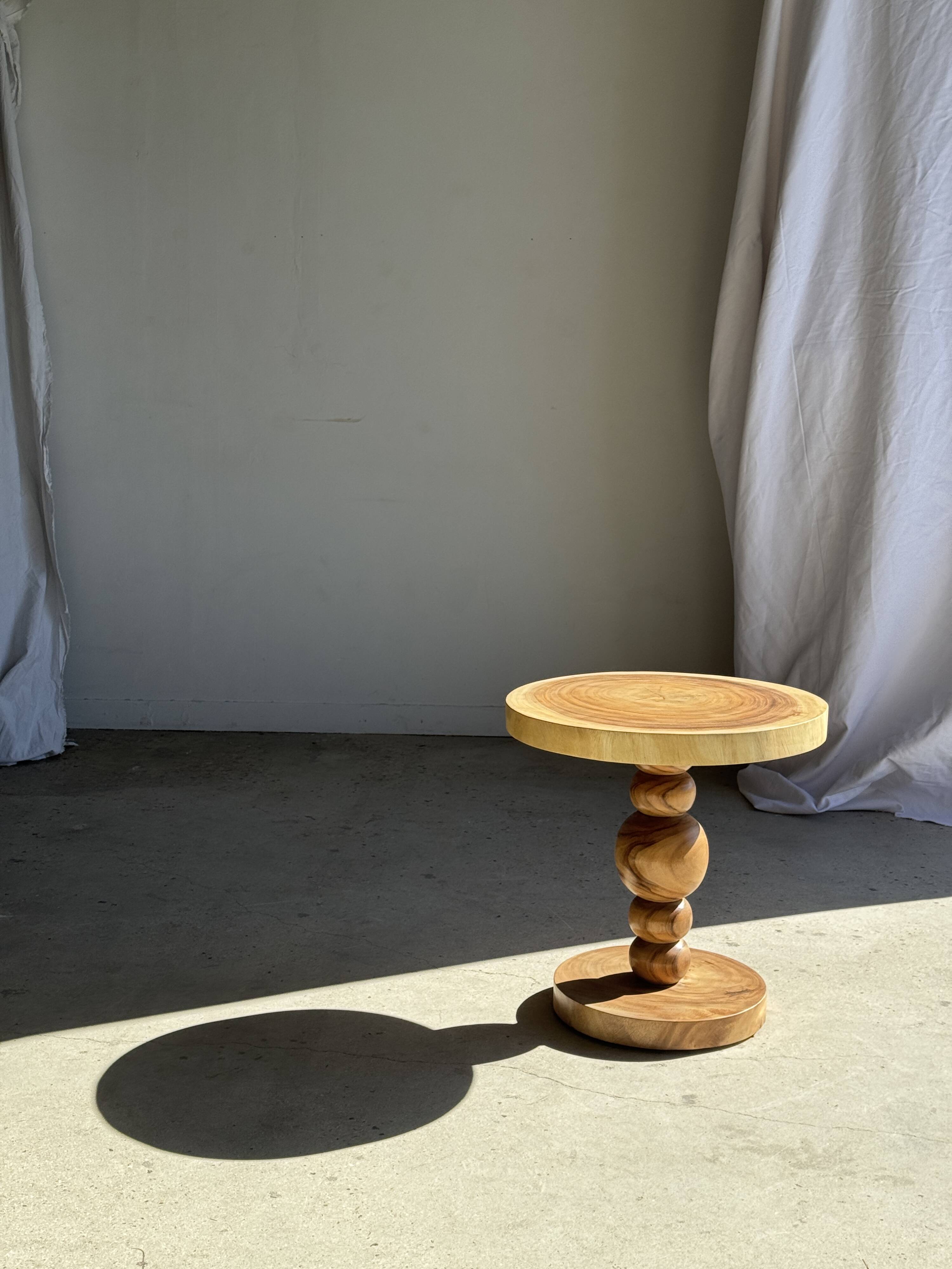 Coffee table in solid suar with central leg and spheres H56.5 D55.5