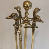 Neoclassical brass fire accessory with duck head decorations.