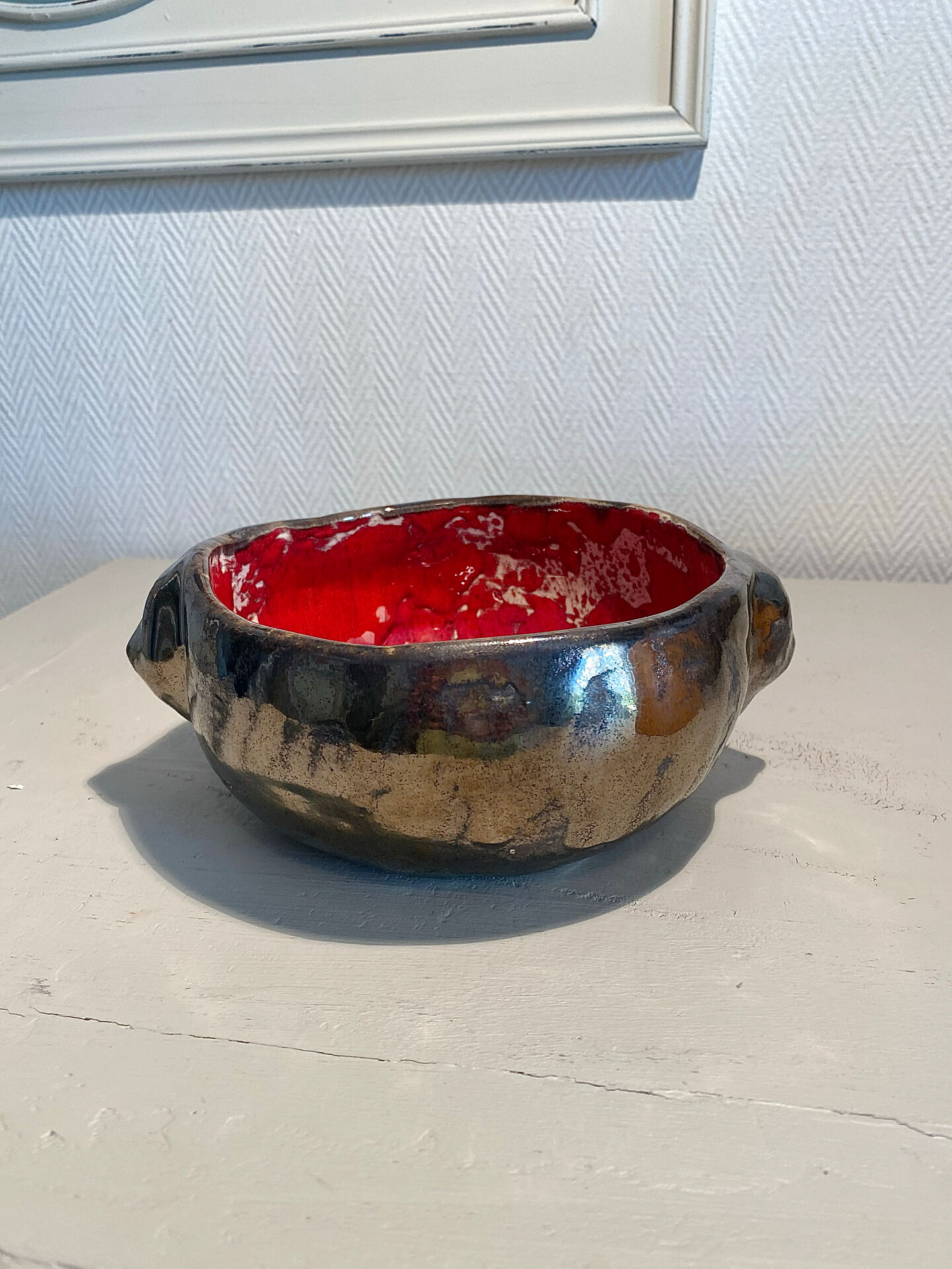 Deep red glazed and metallic ceramic catchall.