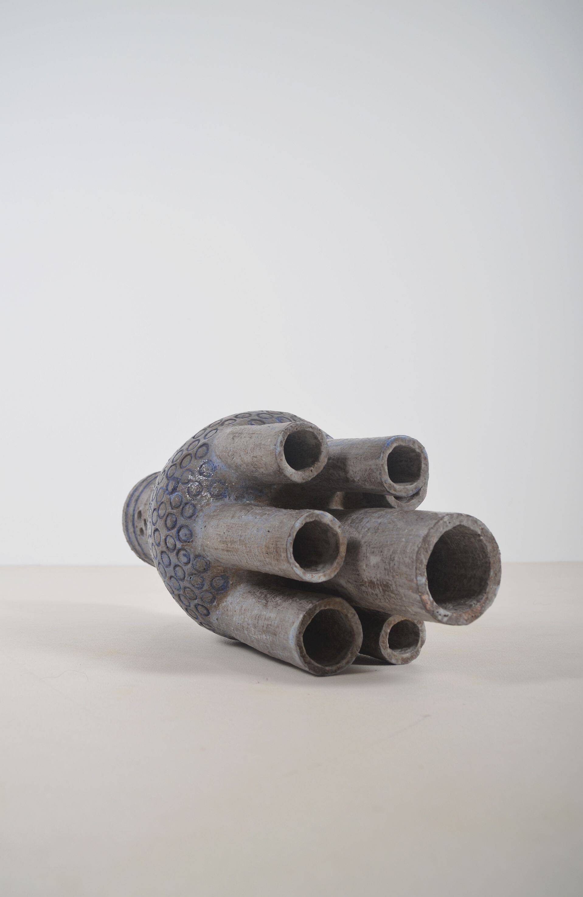 Sculpture en céramique avec des motifs circulaires et une signature.