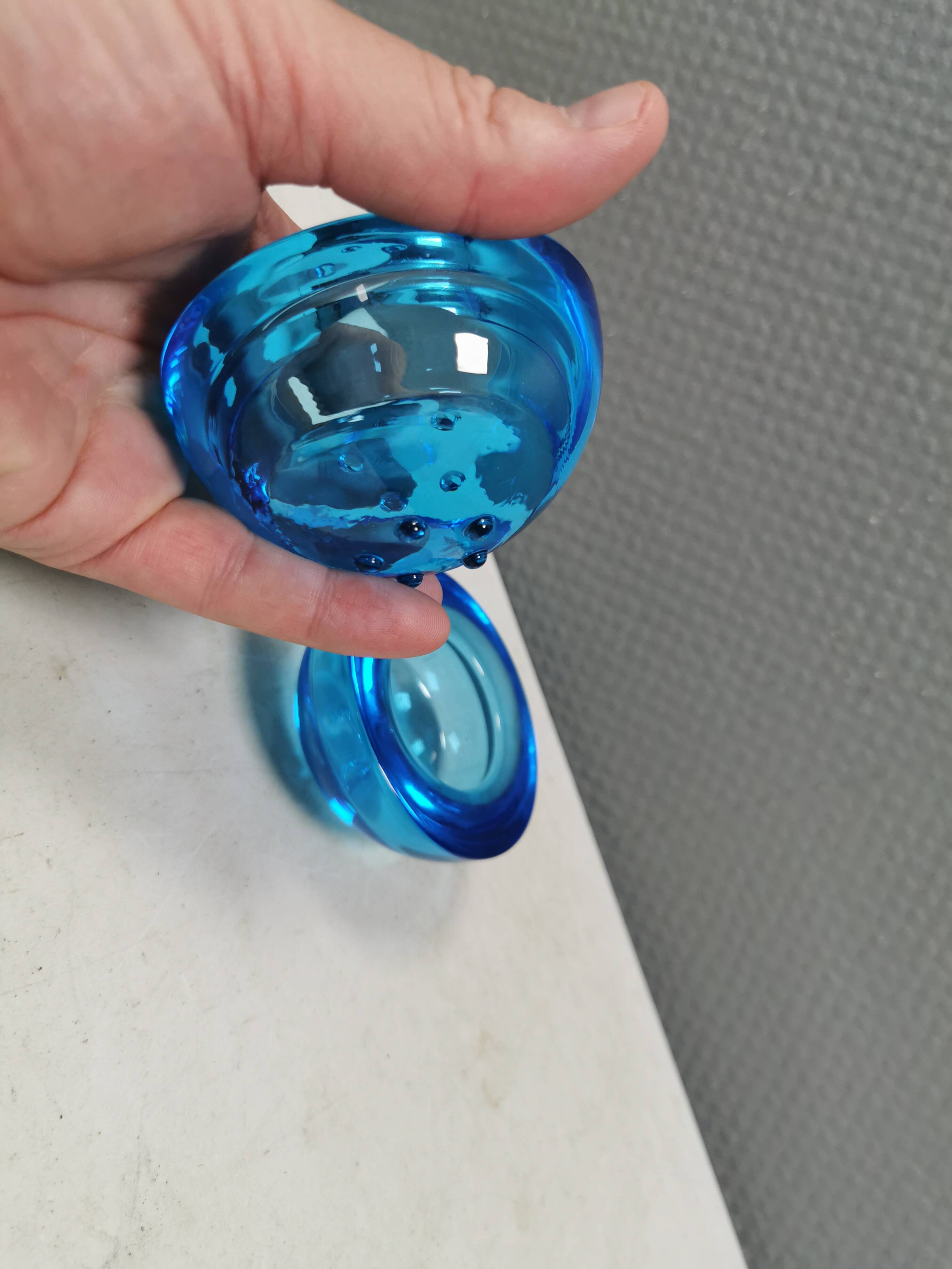 A set of iitalla candle holders in blue transparent glass.
