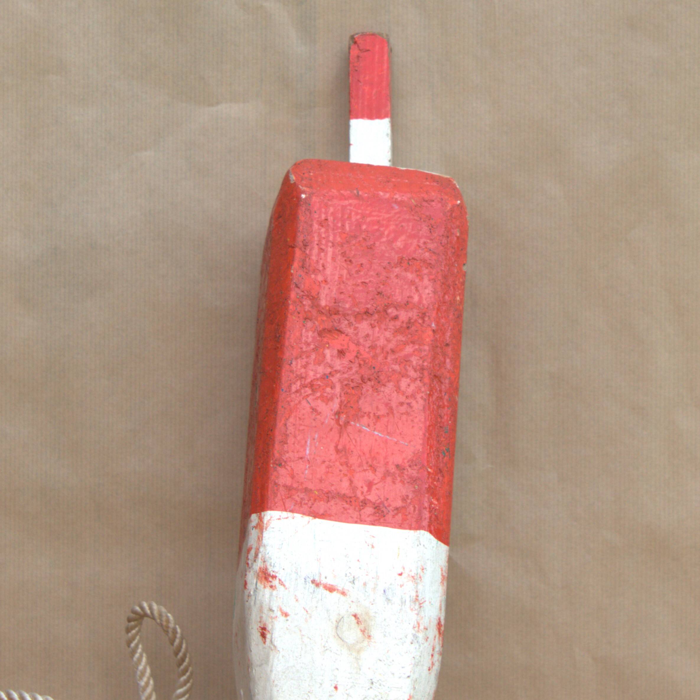 Old red and white wooden buoy