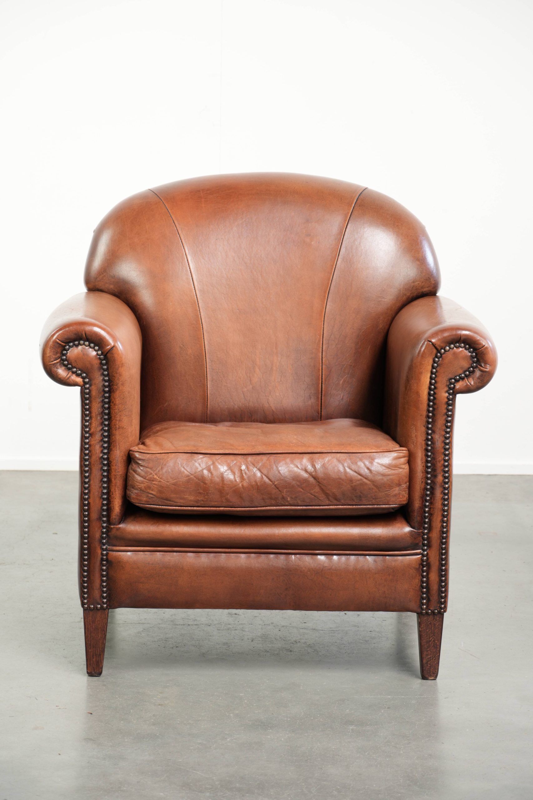 Sheepskin armchair with comfortable seat and finished with decorative nails
