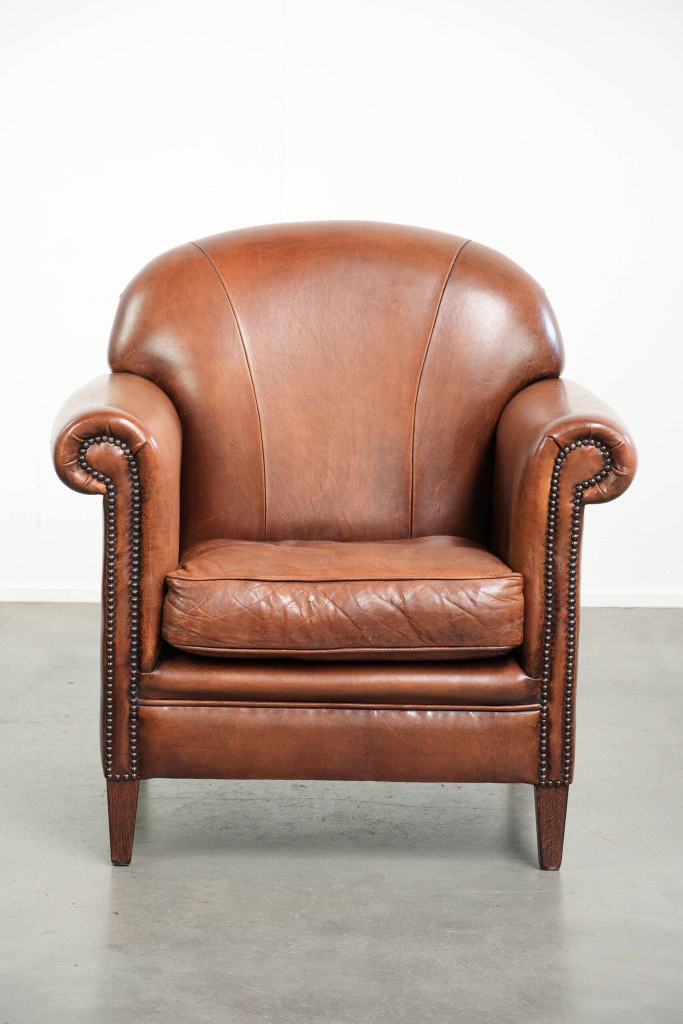 Sheepskin armchair with comfortable seat and finished with decorative nails