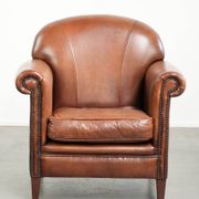 Sheepskin armchair with comfortable seat and finished with decorative nails