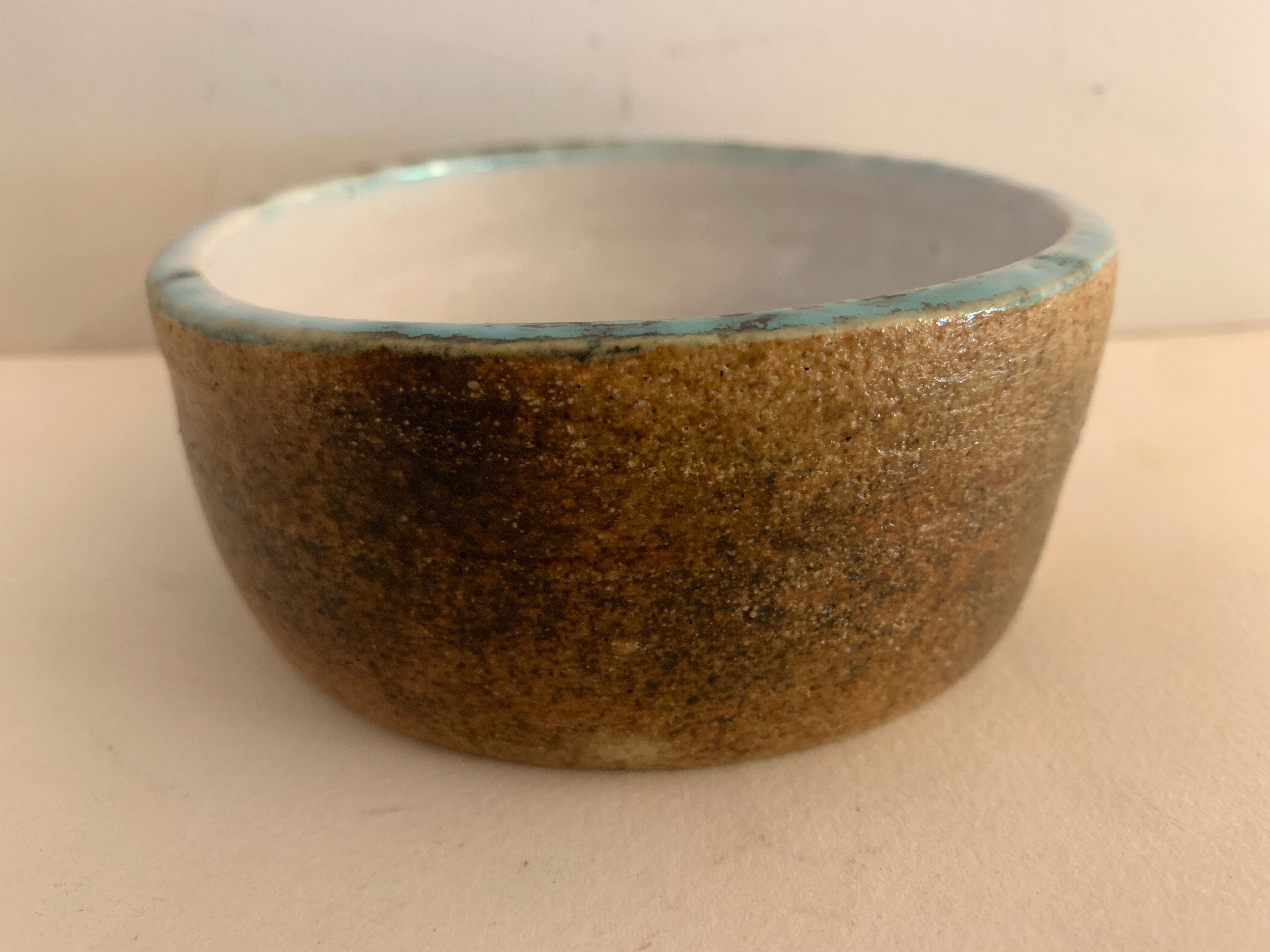 Round ashtray signed in sandstone with glazed interior