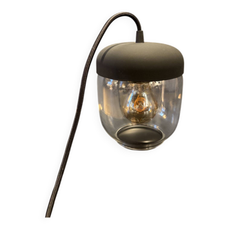 Portable lamp with transparent glass and black plastic.