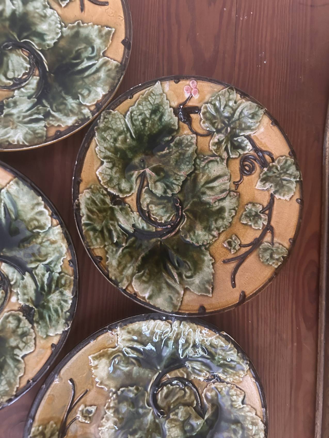 Four antique dessert plates in majolica with vine decoration.