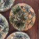 Four antique dessert plates in majolica with vine decoration.