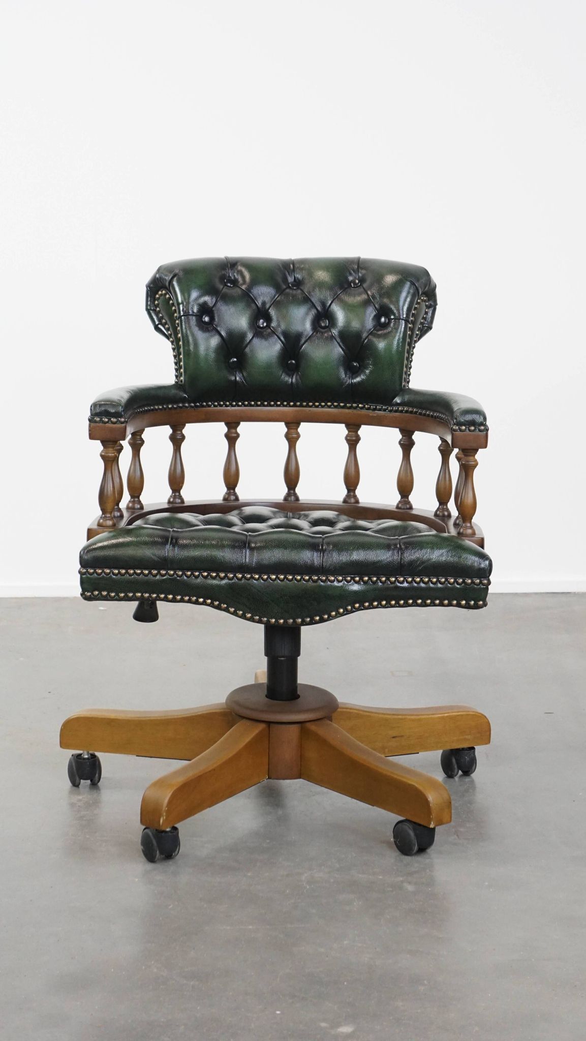 Dark green cowhide leather and wood chesterfield office chair on wheels