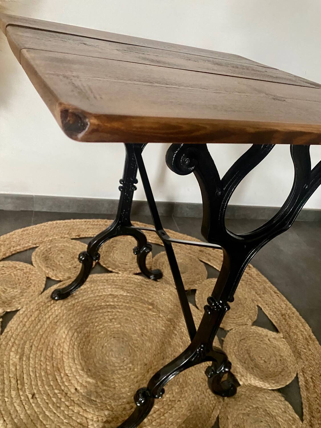 Bistro table with iron legs and raw wood top.