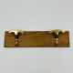 Vintage wall coat rack in brass and wood design.