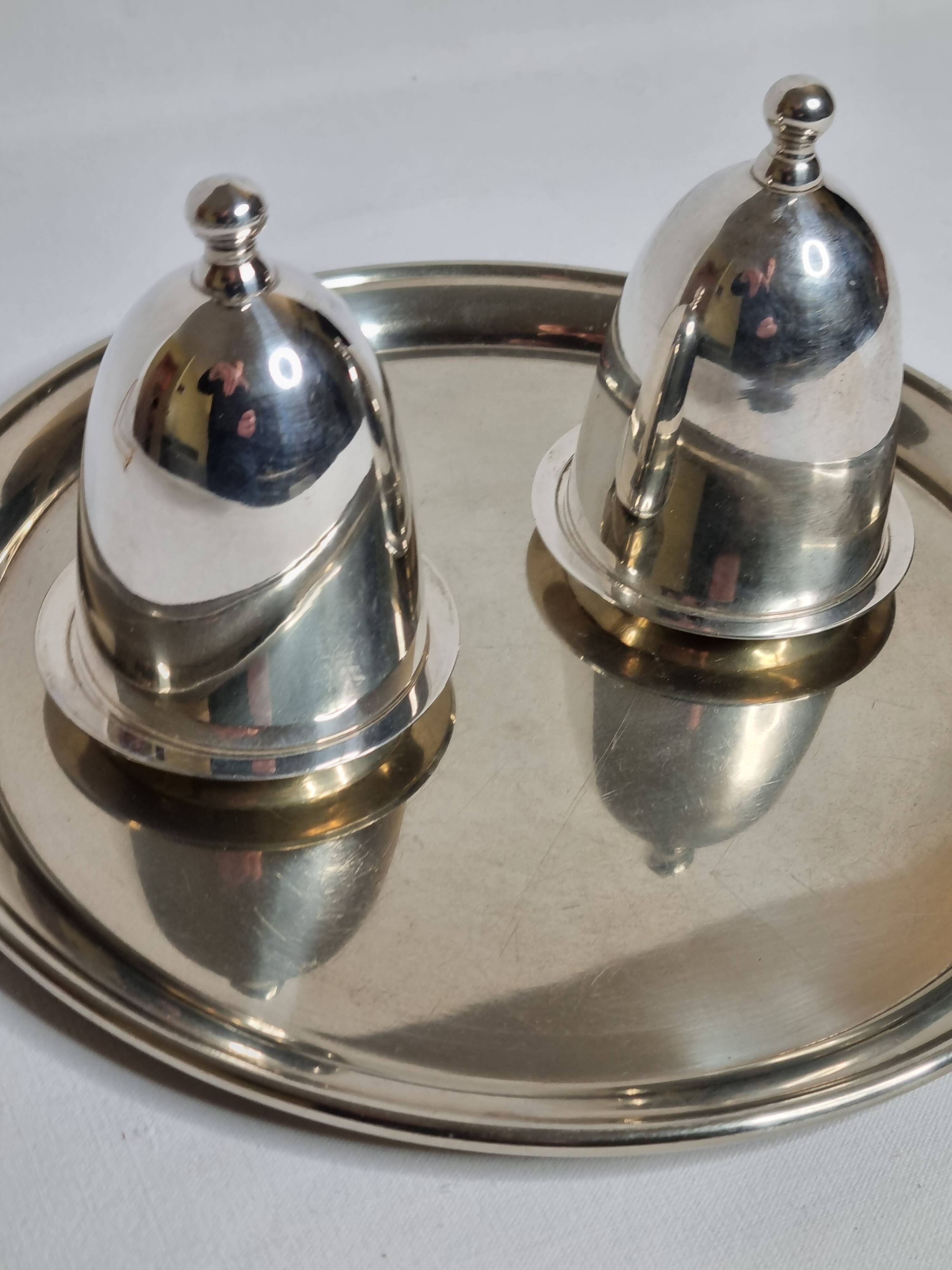 Deux coquetiers sous cloche en métal argenté avec plateau de présentation "Gombault", 28 cm