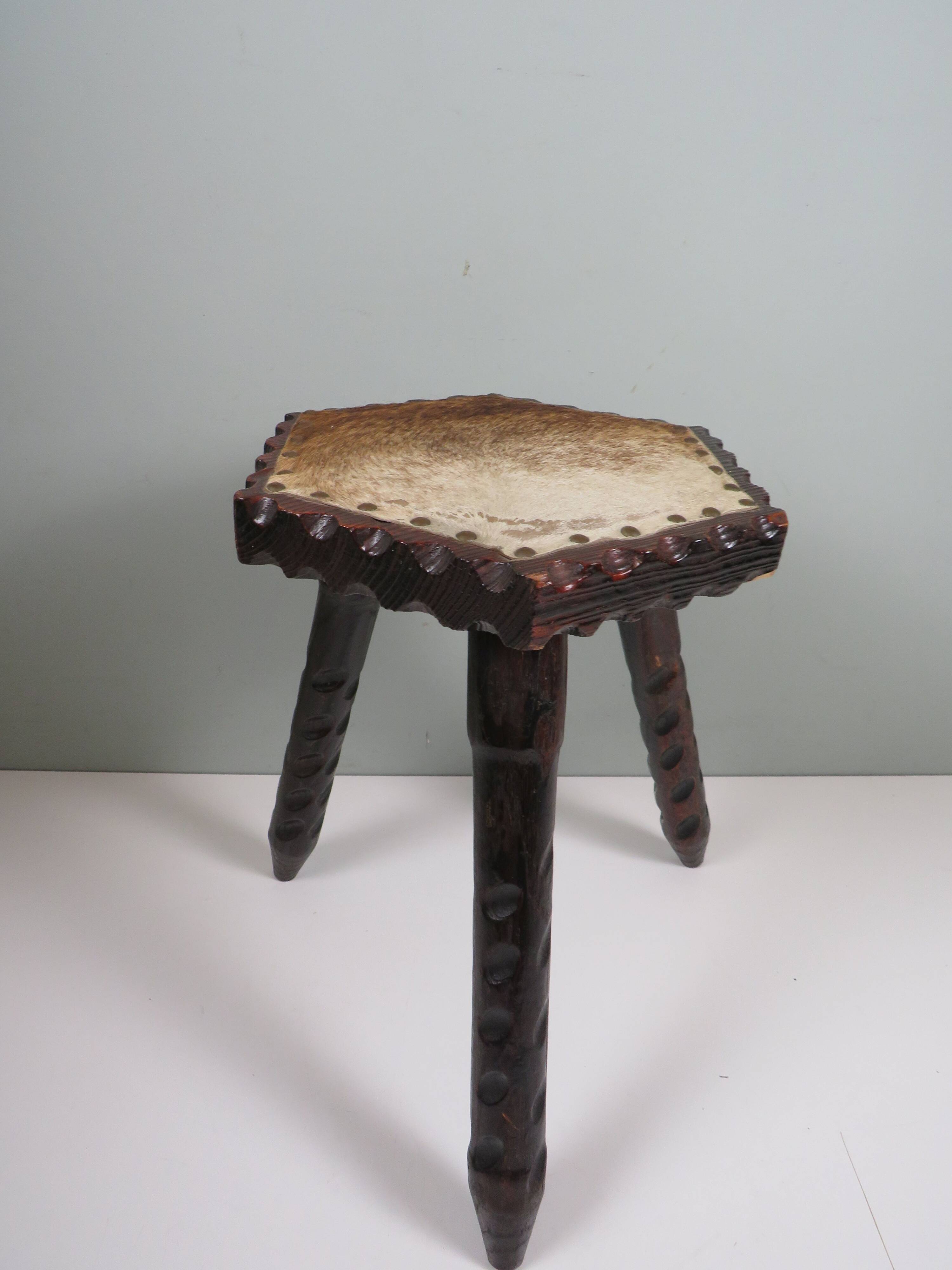 Vintage Spanish stool in carved wood with a leather seat.