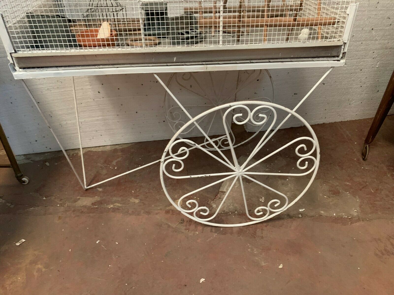 Cage has birds on trolley wheeled wrought iron volière 20th century