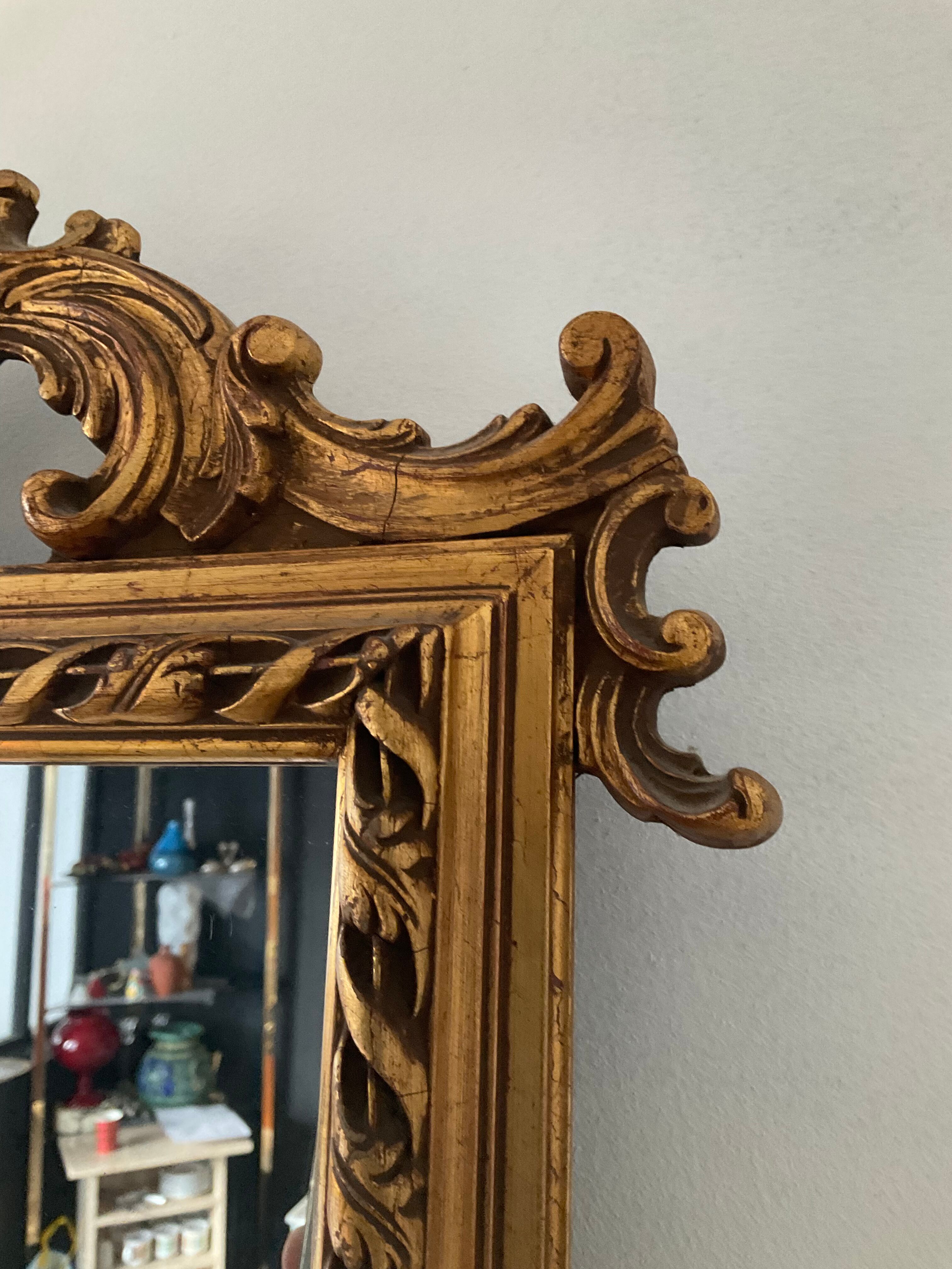 Old pedimented mirror in gilded wood