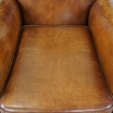 Fauteuil ancien en cuir de mouton couleur cognac