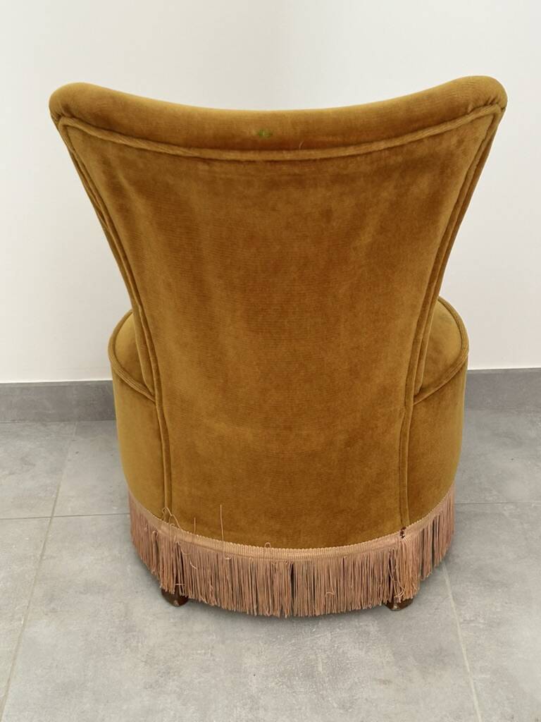 Ochre and fringed pouffe-style armchair