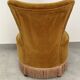 Ochre and fringed pouffe-style armchair