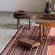 Large Indian rug with red, yellow, and white stripes and geometric fringes.
