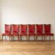 Set of 6 vintage wooden chairs with red faux leather in retro style.