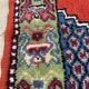 Vintage hand-knotted wool rug with polychrome decoration on a red, blue, green background 150 x 63 cm