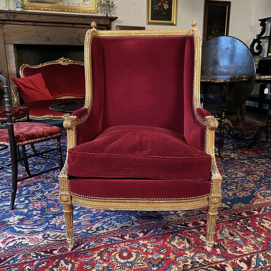Golden wooden bergère in Louis XVI style upholstered in Bordeaux velvet.