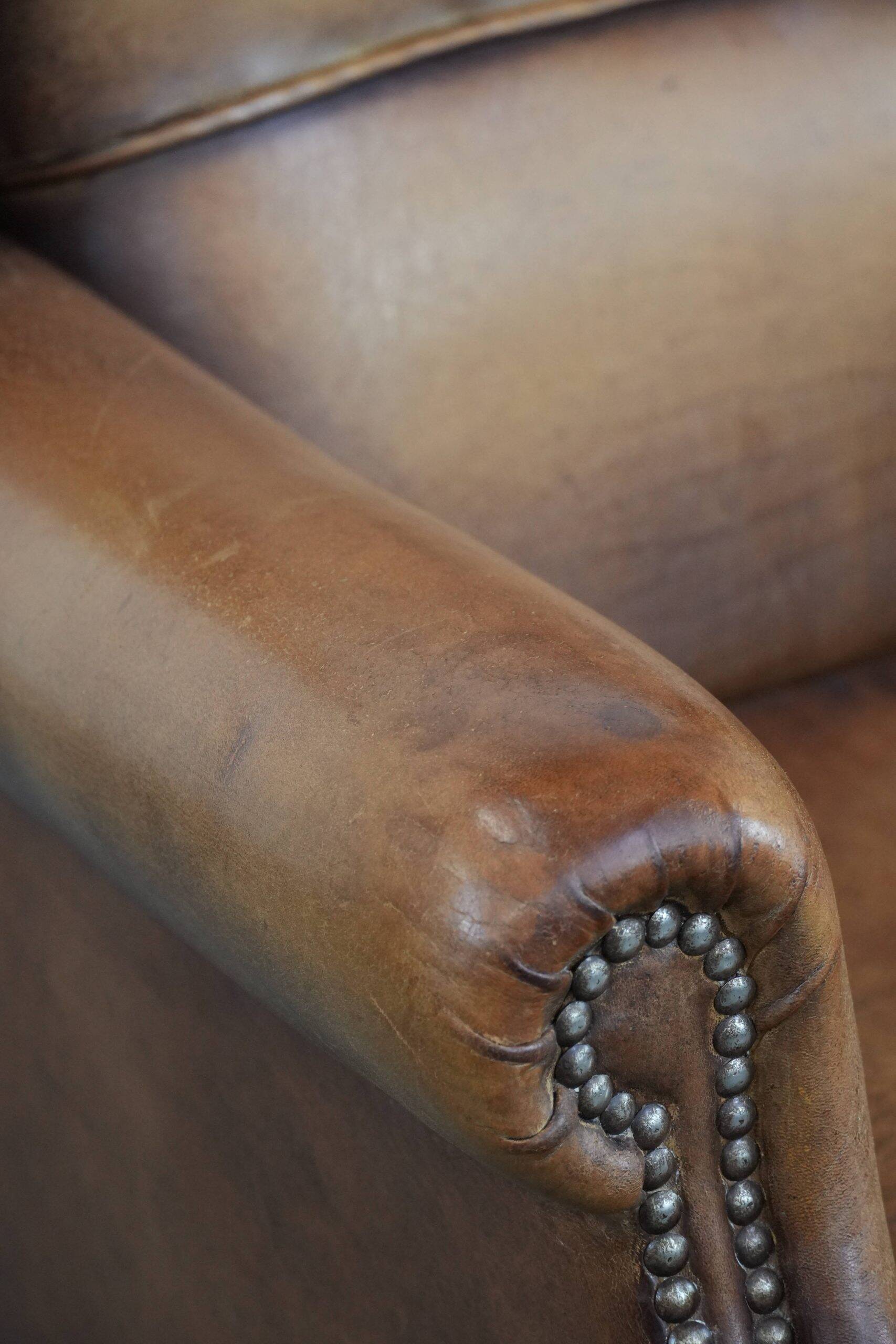 Fauteuil à oreilles en cuir de mouton charmant avec des couleurs chaudes.