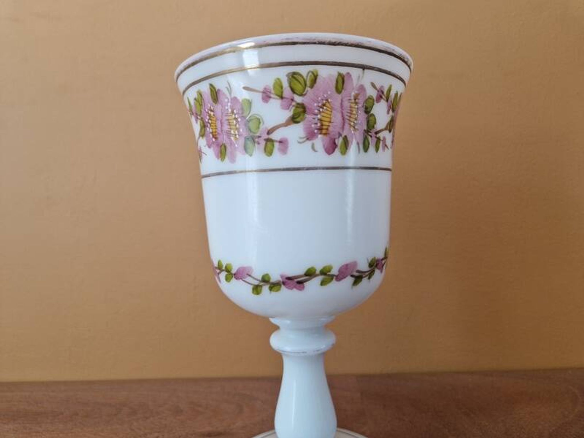Verre sur pied en forme de calice en opaline blanche et décor de fleurs