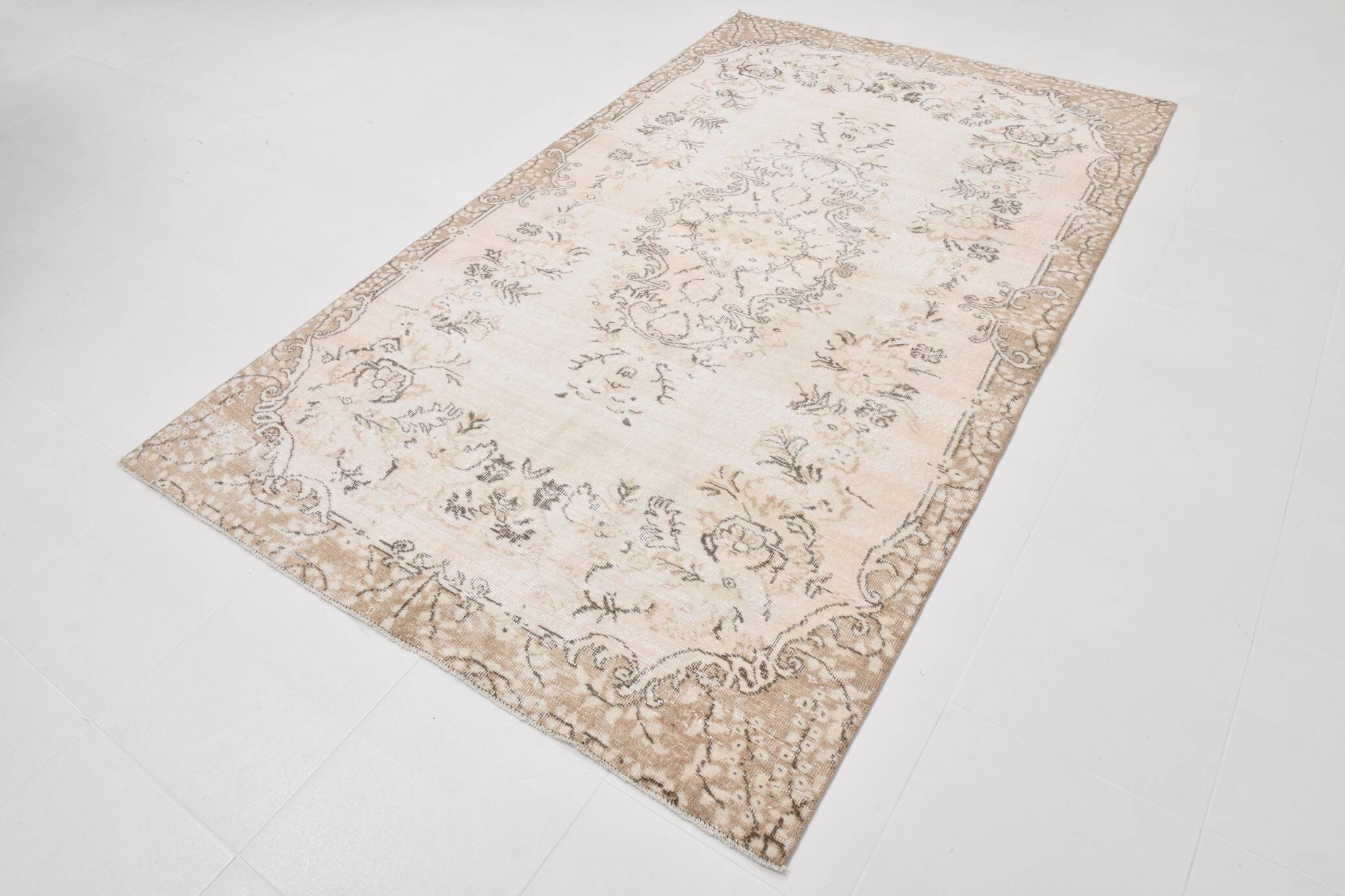 Rare tapis vintage fait main tons rose poudré et beige, motifs floraux