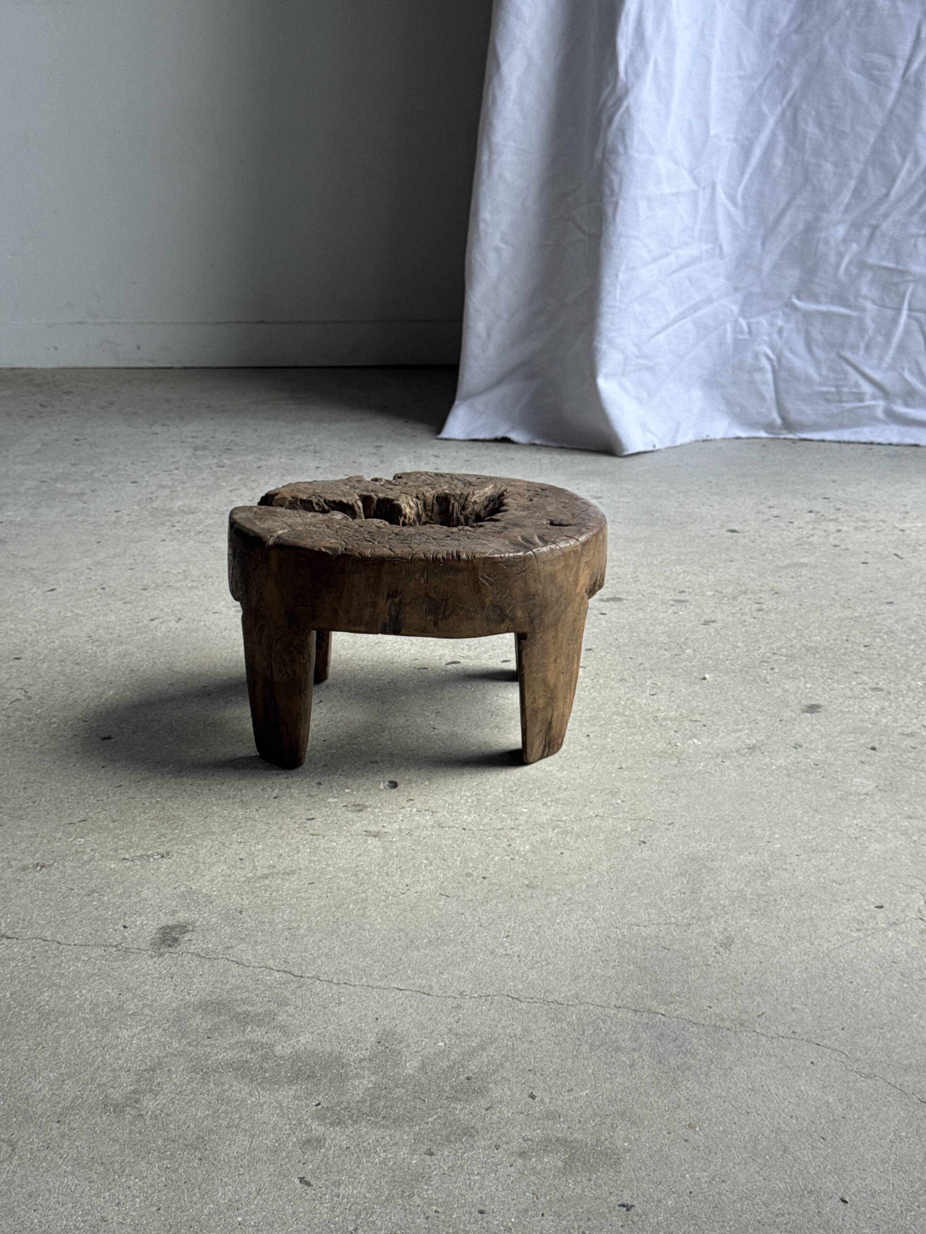 Small low circular four-legged stool in organic old teak with cut-out design H2